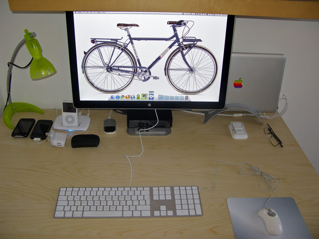 Home desk with laptop, external monitor, and keyboard in a living space